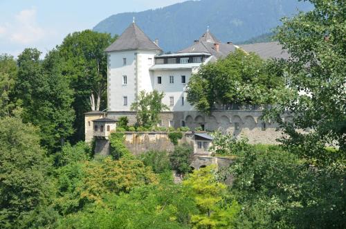 a large white building on a hill with trees at Kloster Wernberg in Wernberg