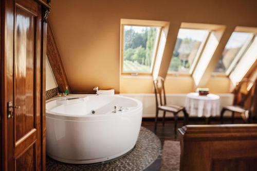 a bathroom with a large white tub in a room at Weingartenhotel Harkamp Südsteiermark in Sankt Nikolai im Sausal
