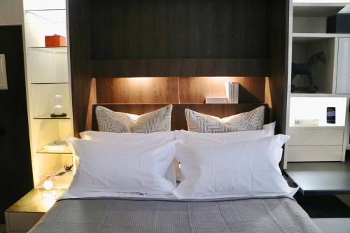a bed with white pillows and a wooden headboard at Èrsextius, GGB1, Aix-en-Provence in Aix-en-Provence