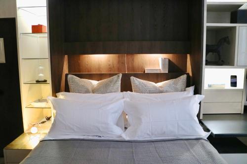 un letto con cuscini bianchi e testiera in legno di Èrsextius, GGB1, Aix-en-Provence ad Aix en Provence