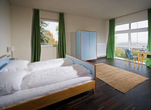 a bedroom with a bed and a desk and window at Weingartenhotel Harkamp Südsteiermark in Sankt Nikolai im Sausal