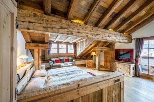 Un dormitorio con una cama grande en una habitación con techos de madera. en Hotel Bellavista, en Silvaplana