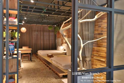 une chambre avec un arbre poussant par la fenêtre dans l'établissement Lukang Yian B&B, à Lukang