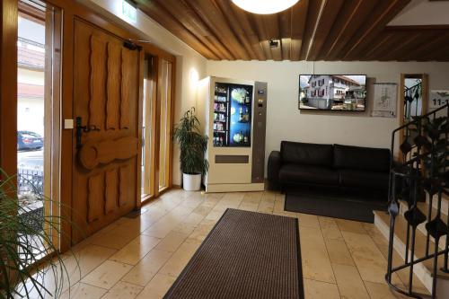 a living room with a black couch and a door at Hotel Heuberger Hof, Wehingen in Wehingen