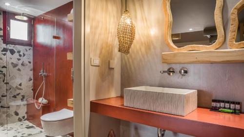 a bathroom with a sink and a toilet and a mirror at Avithos Resort Hotel in Svoronata