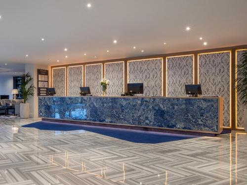 a lobby with a blue marble counter and chairs at The Connacht Hotel in Galway