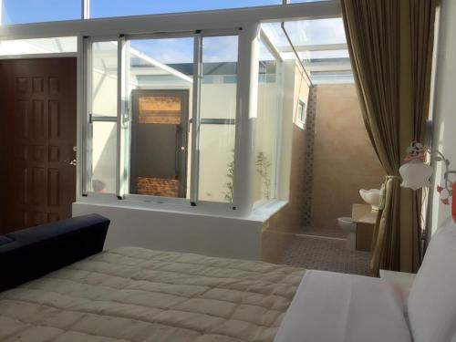 a bedroom with a bed and a large window at Kenting Yeh Zhan in Hengchun