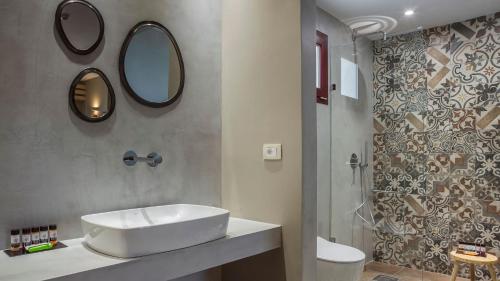 a bathroom with a sink and a mirror and a shower at Avithos Resort Hotel in Svoronata