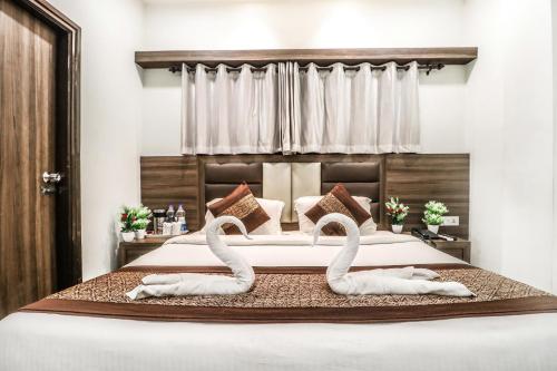 two swans sitting on a bed in a bedroom at Hotel Kings in Amritsar