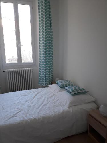 塞特港的住宿－Le V Génie verdure et calme à deux pas des Halles de Sète，卧室内的一张白色床,设有窗户