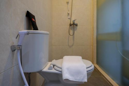 RedDoorz Syariah near Alun Alun Kebumen في Kebumen: حمام مع مرحاض أبيض ودش