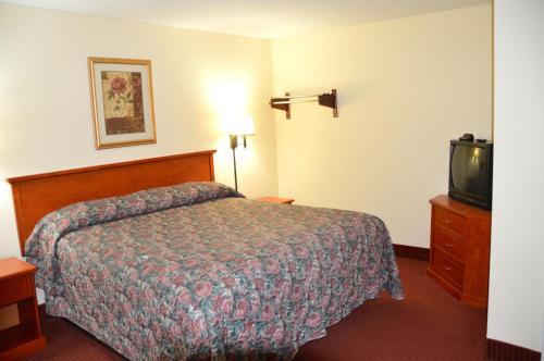 a hotel room with a bed and a tv at Crown Inn Motel Yorktown in Yorktown