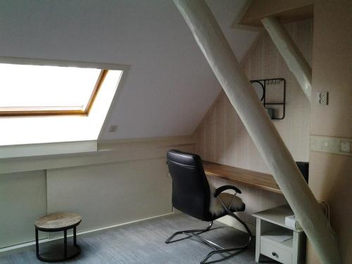 an attic office with a chair and a window at Bed & Breakfast Meinsma in Moddergat