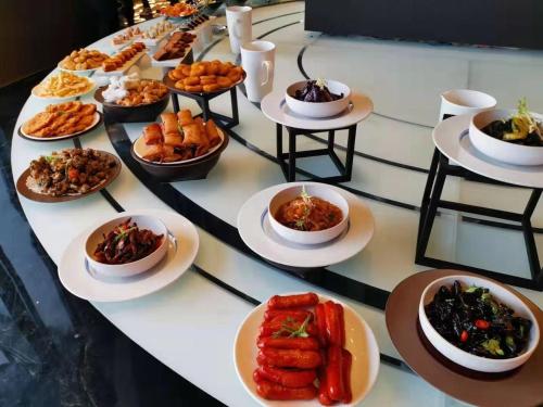 a buffet of food on a table with plates of food at Mercure Xiamen Zhongshan Road Pedestrian Street Seaview in Xiamen