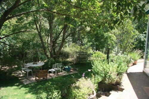 a garden with a table and chairs and trees at The Gate Guesthouse in Clarens