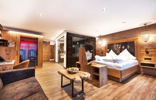 a hotel room with a bed and a couch at Wellness- und Bierhotel Adam Bräu in Bodenmais