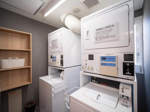 函館市にあるスーパーホテル函館の部屋に白い家電製品が備わったキッチン