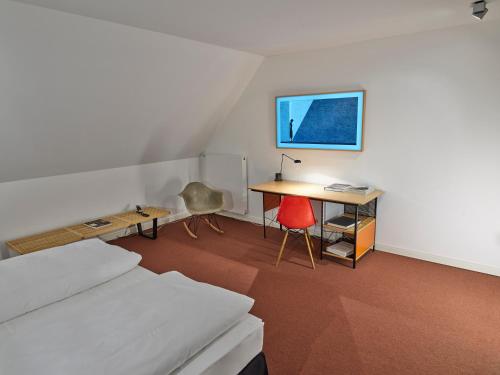 a room with a bed and a desk and a table at THE QVEST hideaway in Cologne