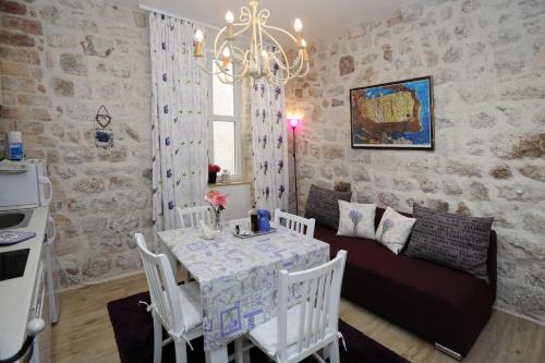 a kitchen and dining room with a table and a couch at L & L Old Town Apartments in Dubrovnik