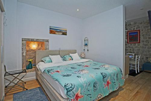 a bedroom with a bed with a blue comforter at L & L Old Town Apartments in Dubrovnik