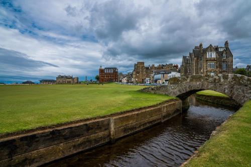 a stone bridge over a river in a city at No1 Apartments & Bedrooms St Andrews - St Mary's in St. Andrews