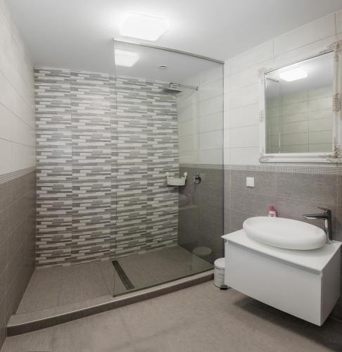 a bathroom with a shower and a toilet and a sink at Corso Lux Apartman in Gyula