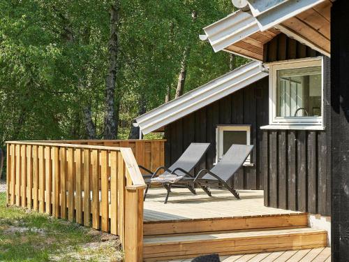 a wooden deck with two chairs on a house at 8 person holiday home in Nex in Neksø