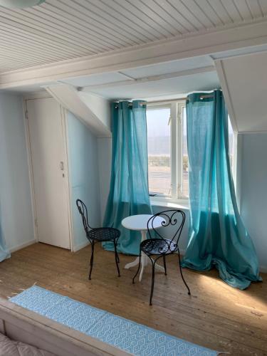 a room with two chairs and a table and a window at Pacific, spectacular seaview in Bergen aan Zee