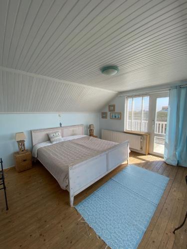a bedroom with a large bed with a white ceiling at Pacific, spectacular seaview in Bergen aan Zee