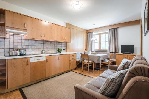 a kitchen and living room with a couch and a table at Residence Floralp in Colfosco