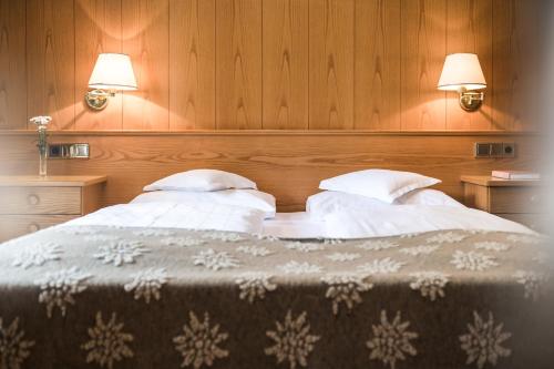 a bedroom with two beds with white pillows at Residence Floralp in Colfosco