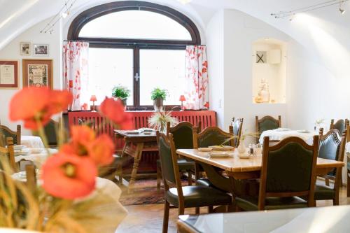 ein Restaurant mit Tischen und Stühlen und einem Fenster in der Unterkunft Hotel Wolf in Salzburg