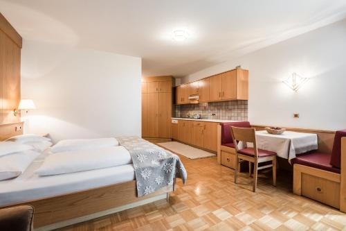 a hotel room with a bed and a kitchen at Residence Floralp in Colfosco