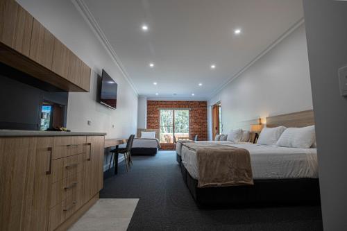 a bedroom with a bed and a desk in a room at Red Waratah Accommodation in Bendigo