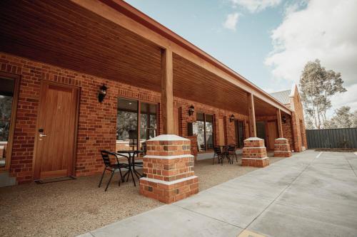 a brick building with a table and chairs on a patio at Red Waratah Accommodation in Bendigo