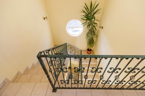 a staircase with a round window and a plant at Invest Vendégház in Eger