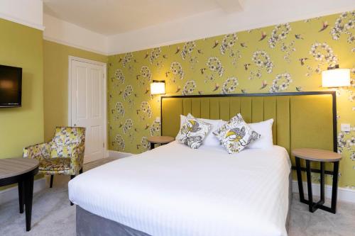 a hotel room with a bed and a chair at Wisteria Hotel in Oakham
