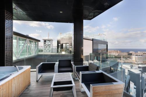 a balcony with a tub and a view of the city at Hugo's Boutique Hotel - Adults Only in St Julian's