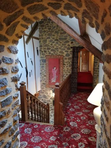 une chambre avec un mur en pierre et un escalier dans une maison dans l'établissement Les Petites Chapelles, à Saint-Pierre-de-Plesguen