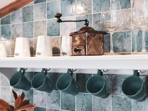 a shelf with cups and wine glasses on it at Apartments Vela in Piran