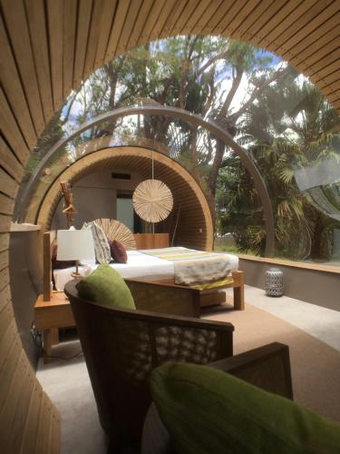 a room with a bed and a circular room with a tree at Bubble Lodge Ile aux Cerfs Island in Ile aux Cerfs