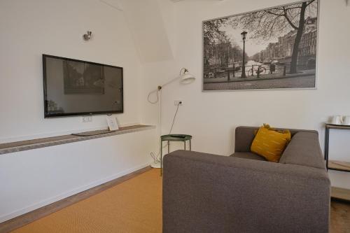 a living room with a couch and a flat screen tv at Het Gecroonde Swaert B&B in Middelburg