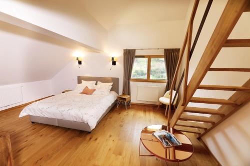 a bedroom with a bed and a staircase at Maison d'hôtes & SPA La Scierie in Salins-les-Bains