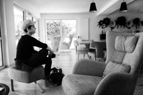 a woman sitting on a chair in a living room at Maison d'hôtes & SPA La Scierie in Salins-les-Bains