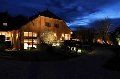 un granero iluminado por la noche con luces en Maison d'hôtes & SPA La Scierie, en Salins-les-Bains