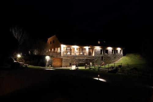 a large stone building with lights on it at night at Maison d'hôtes & SPA La Scierie in Salins-les-Bains