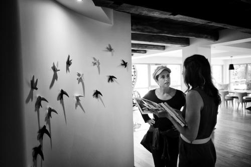 two women standing in a room with birds on the wall at Maison d'hôtes & SPA La Scierie in Salins-les-Bains