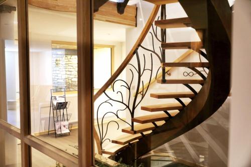 a spiral staircase in a house with a glass window at Maison d'hôtes & SPA La Scierie in Salins-les-Bains