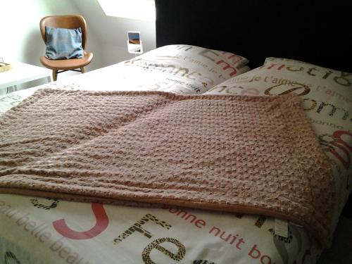 a bed with a brown knitted blanket on it at Bed & Breakfast Meinsma in Moddergat