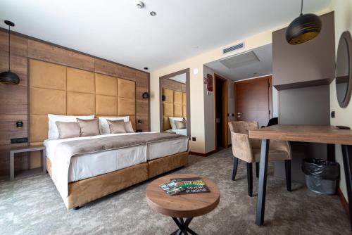 a hotel room with a large bed and a table at Hotel Mirjana & Rastoke in Slunj